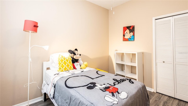 bedroom with dark hardwood / wood-style floors and a closet