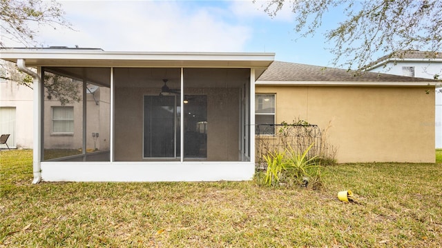 back of property featuring a sunroom and a yard