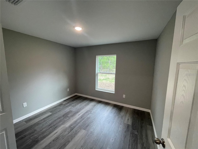 unfurnished room with dark hardwood / wood-style flooring