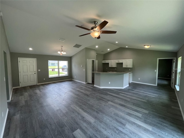 unfurnished living room featuring lofted ceiling, dark hardwood / wood-style floors, and ceiling fan with notable chandelier