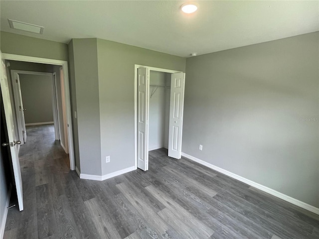 unfurnished bedroom with dark wood-style floors, a closet, visible vents, and baseboards