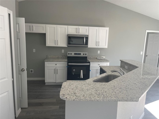 kitchen featuring stainless steel microwave, electric range oven, white cabinets, vaulted ceiling, and a sink