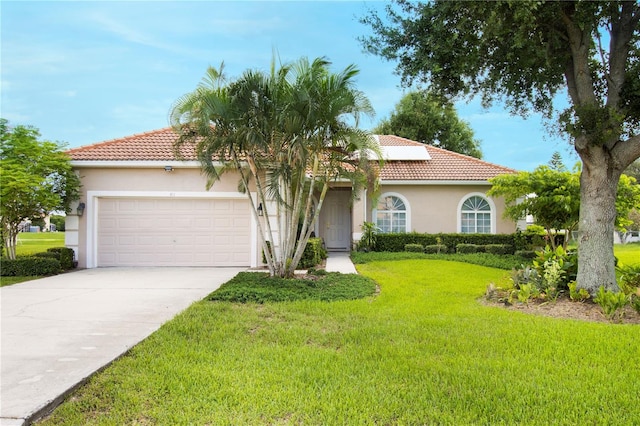 mediterranean / spanish-style home with a garage and a front lawn