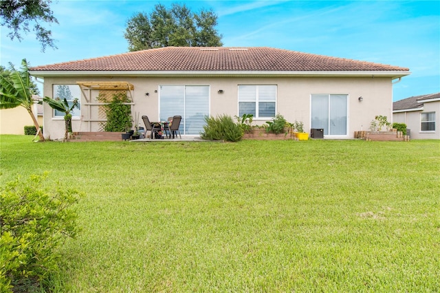 rear view of property with a yard and a patio area