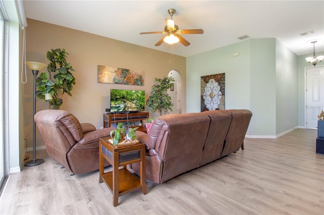 living room featuring ceiling fan with notable chandelier and light hardwood / wood-style floors