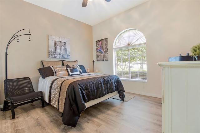 bedroom with light hardwood / wood-style flooring, ceiling fan, and vaulted ceiling