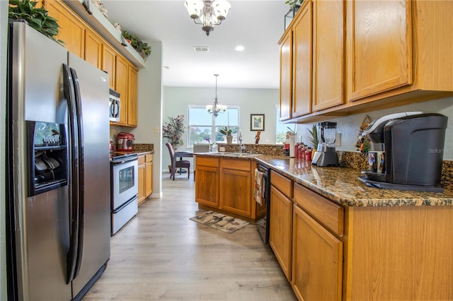 kitchen featuring appliances with stainless steel finishes, light hardwood / wood-style flooring, kitchen peninsula, hanging light fixtures, and a notable chandelier