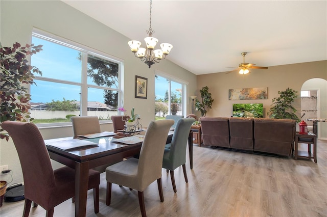 dining space with ceiling fan with notable chandelier and light wood-type flooring