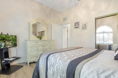 bedroom with high vaulted ceiling and light hardwood / wood-style floors