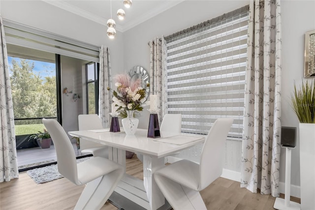 dining space with light hardwood / wood-style floors and ornamental molding