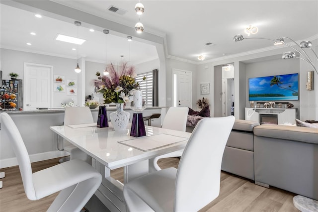 dining room featuring light hardwood / wood-style flooring and ornamental molding