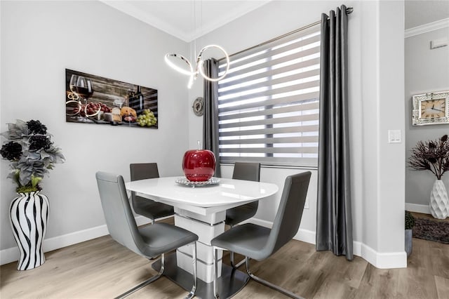 dining space with light wood-type flooring and ornamental molding