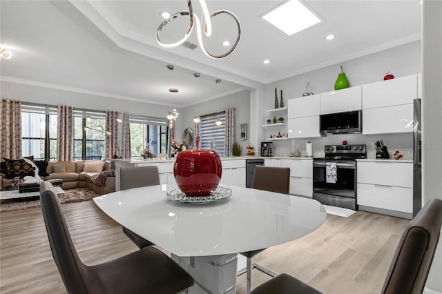 dining space with light hardwood / wood-style floors, an inviting chandelier, and crown molding