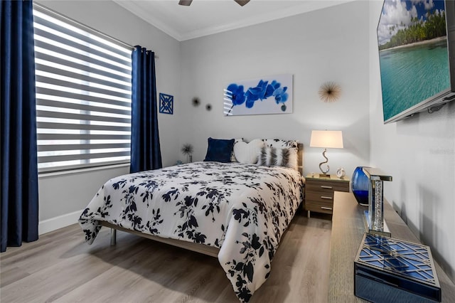 bedroom with ornamental molding, wood-type flooring, and ceiling fan