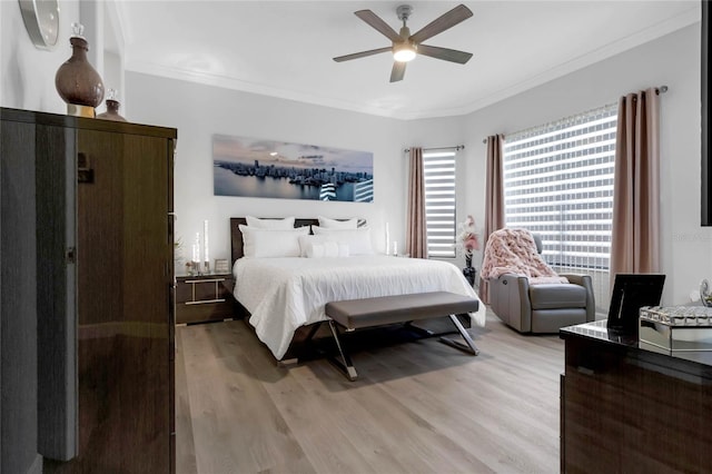 bedroom with ornamental molding, ceiling fan, and light wood-type flooring