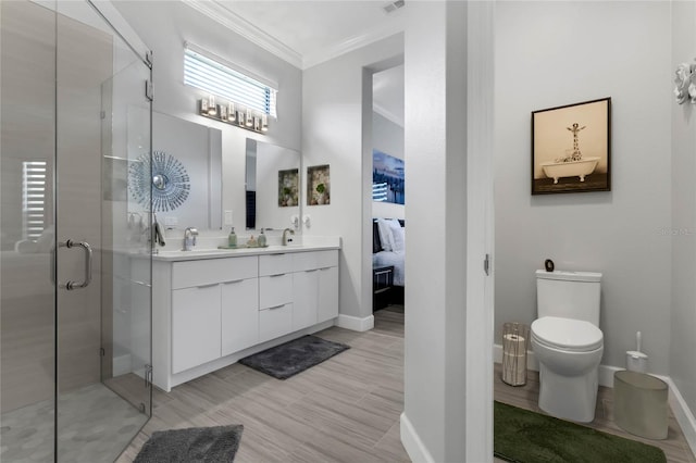 bathroom featuring a shower with door, ornamental molding, dual bowl vanity, and toilet