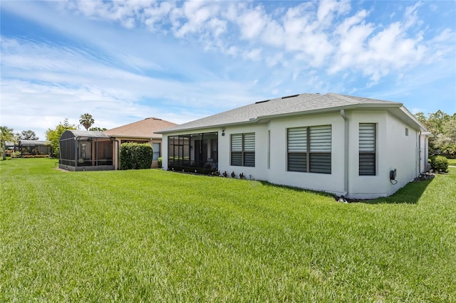 back of house featuring a sunroom and a lawn