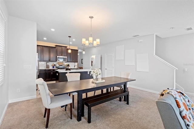 carpeted dining area featuring a notable chandelier and sink