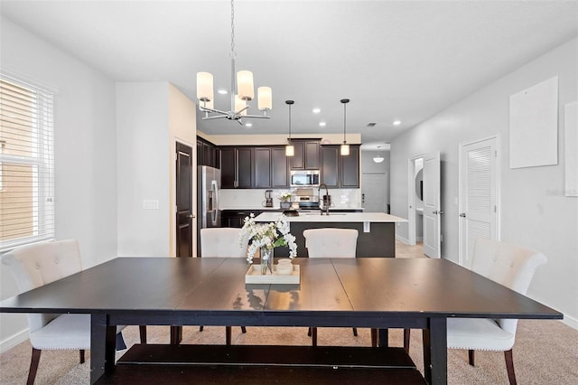 dining area with a healthy amount of sunlight, sink, and a notable chandelier