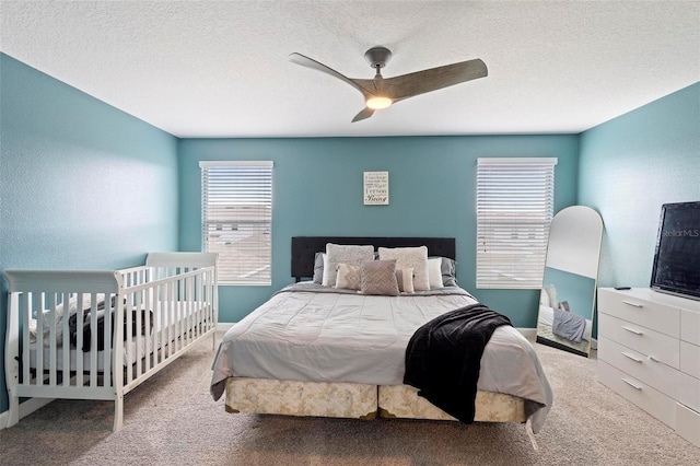 carpeted bedroom with ceiling fan and a textured ceiling