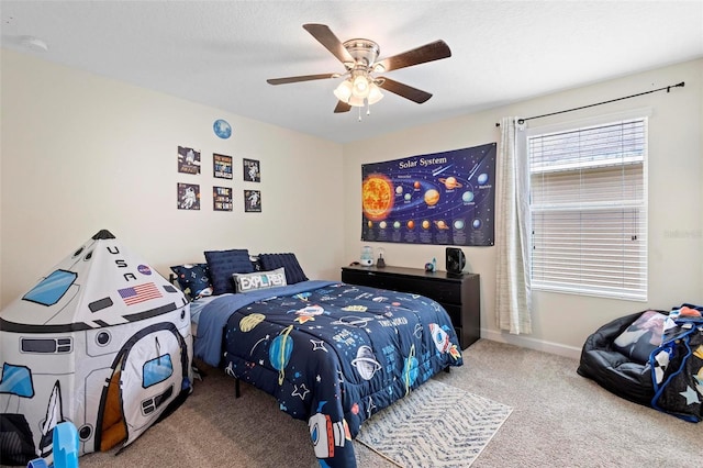 carpeted bedroom featuring ceiling fan and a textured ceiling