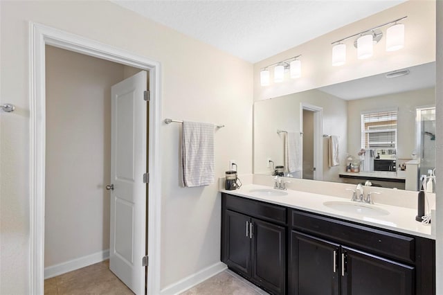 bathroom with vanity, tile patterned flooring, and a textured ceiling