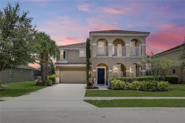 mediterranean / spanish-style home with a lawn, a balcony, and a garage