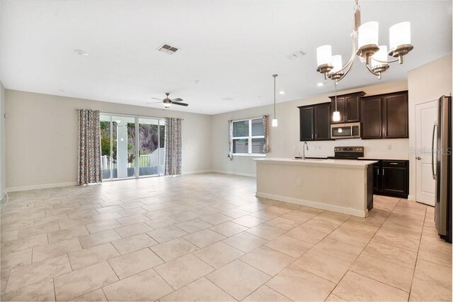 kitchen featuring a kitchen island with sink, light tile patterned floors, pendant lighting, and stainless steel appliances