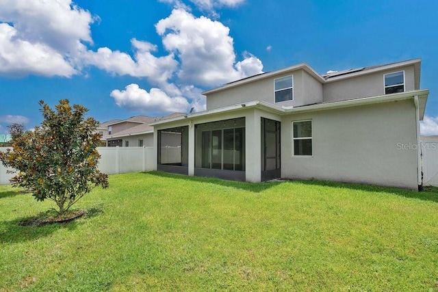 back of property featuring a sunroom and a lawn