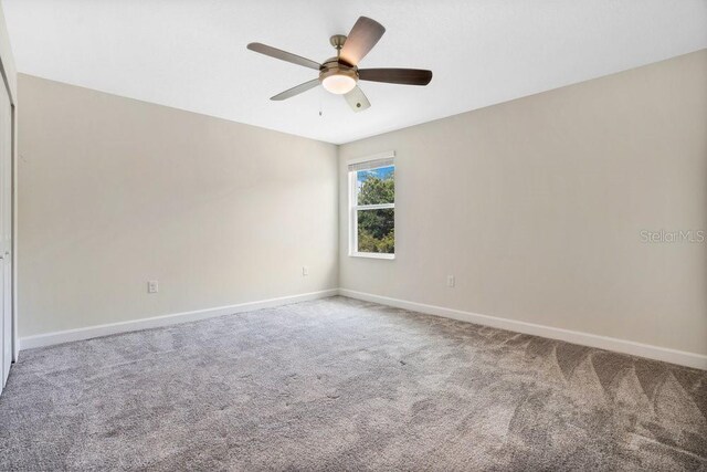 carpeted empty room featuring ceiling fan