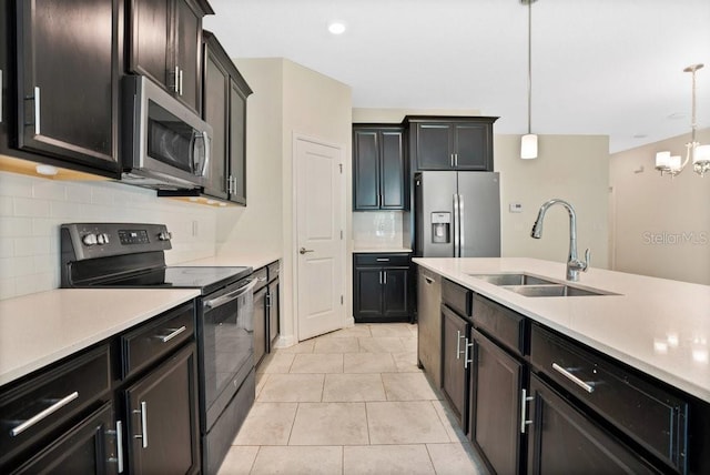 kitchen with appliances with stainless steel finishes, light tile patterned floors, backsplash, and decorative light fixtures