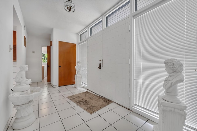 entryway featuring light tile patterned flooring and a textured ceiling