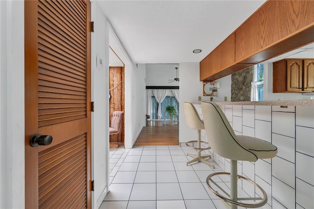 kitchen featuring ceiling fan, a textured ceiling, and light tile patterned floors