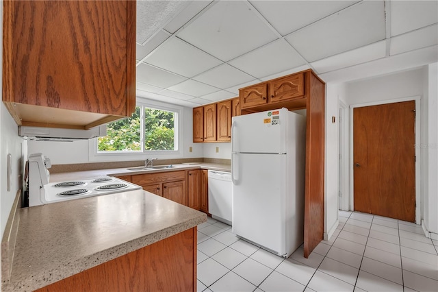 kitchen featuring a drop ceiling, sink, white appliances, and light tile patterned floors