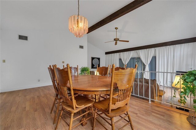 dining space with beam ceiling, high vaulted ceiling, ceiling fan with notable chandelier, and light wood-type flooring