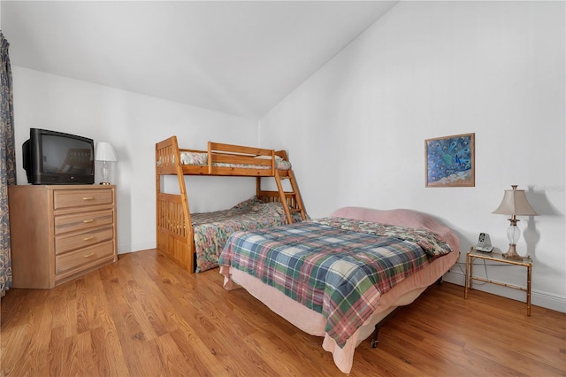 bedroom featuring lofted ceiling and light hardwood / wood-style flooring