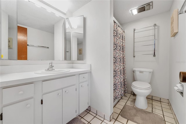 bathroom with tile patterned flooring, vanity, a textured ceiling, and toilet