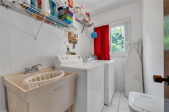 clothes washing area featuring light tile patterned flooring, sink, and washing machine and clothes dryer