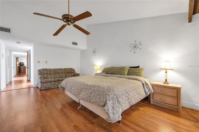 bedroom with ceiling fan, lofted ceiling, and wood-type flooring