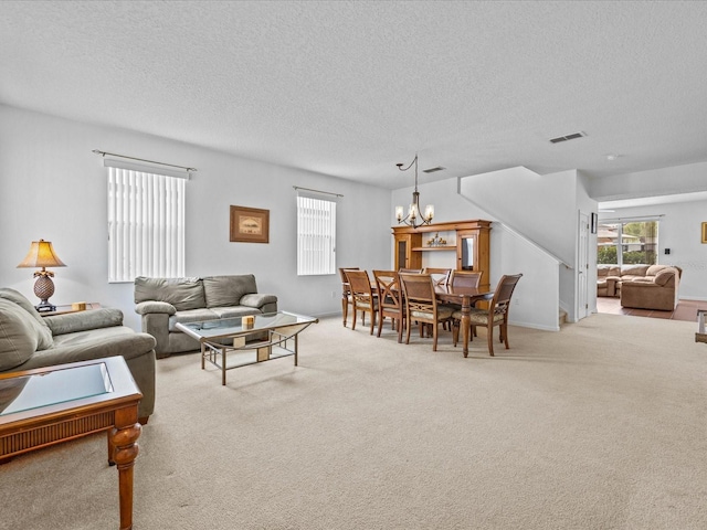 carpeted living room featuring a textured ceiling and a notable chandelier