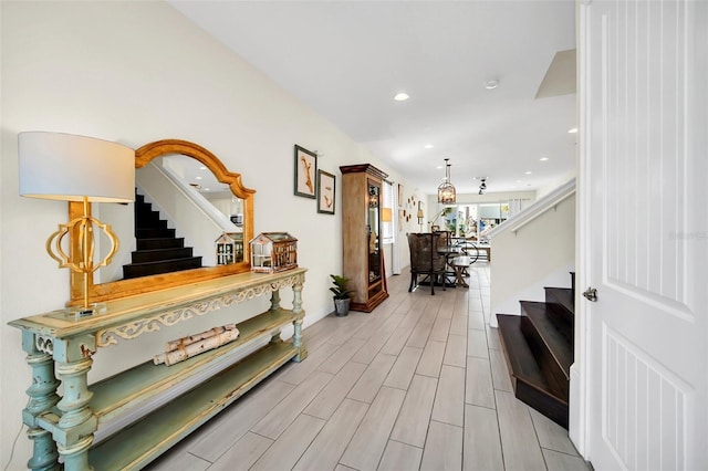hallway featuring wood tiled floor, recessed lighting, and stairway