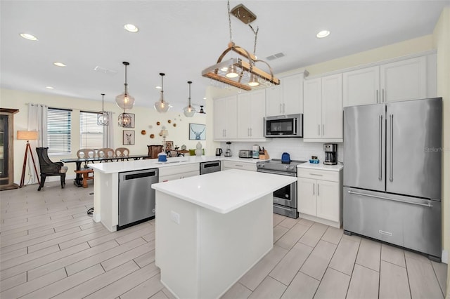 kitchen with kitchen peninsula, pendant lighting, decorative backsplash, and high quality appliances