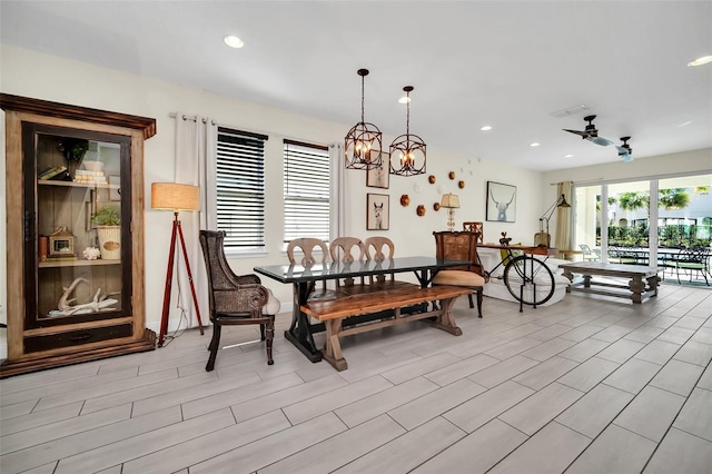 dining space featuring ceiling fan with notable chandelier