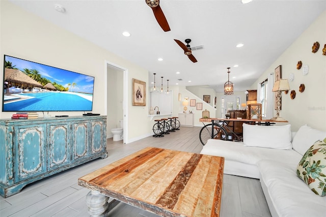 living room with light hardwood / wood-style flooring and ceiling fan