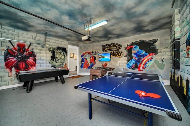 recreation room with baseboards and speckled floor
