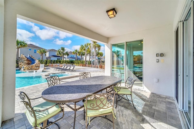 view of patio featuring a community pool, a jacuzzi, and outdoor dining space