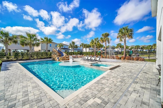 pool featuring a hot tub, fence, and a patio area
