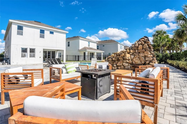 view of patio / terrace with fence and an outdoor living space with a fire pit