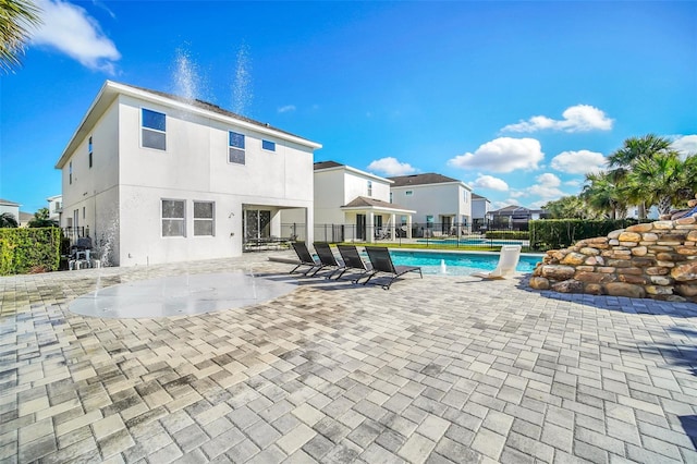 view of pool with a patio and pool water feature