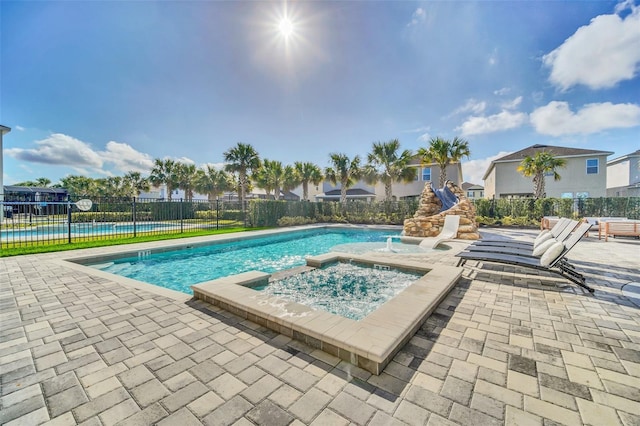 view of pool with a patio, fence, a fenced in pool, and an in ground hot tub